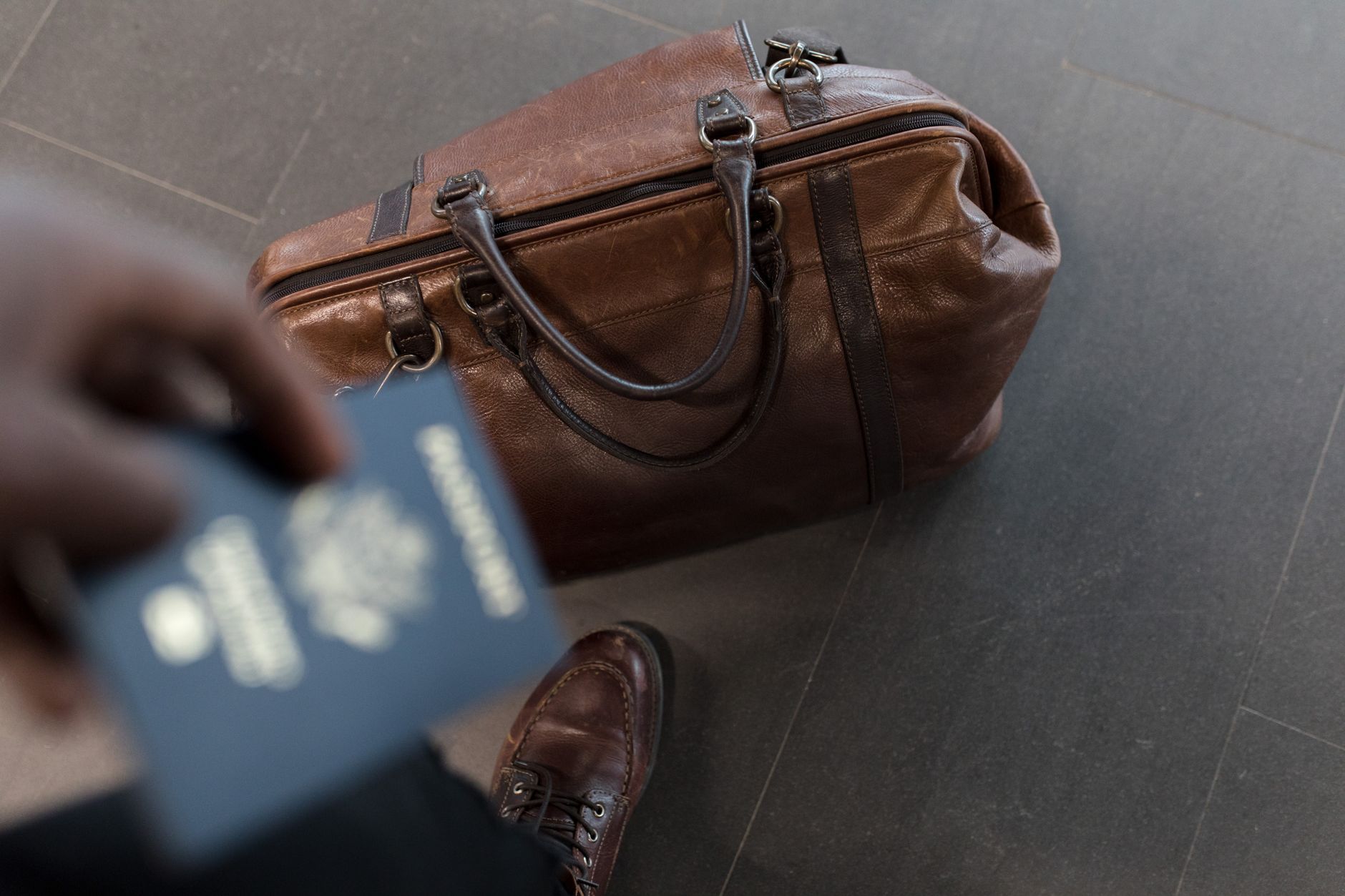 Calator cu bagaj de mana merge prin terminalul aeroportului spre poarta de imbarcare