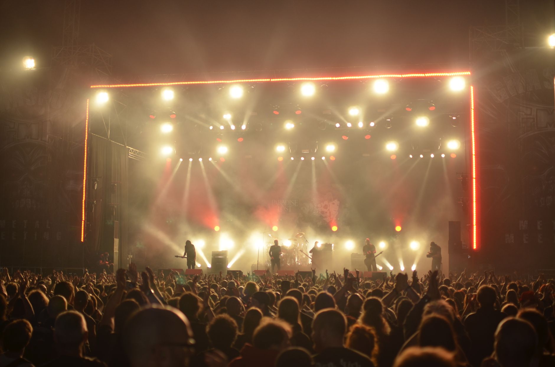 Scena de concert rock cu chitarist si lumini puternice indreptate spre public