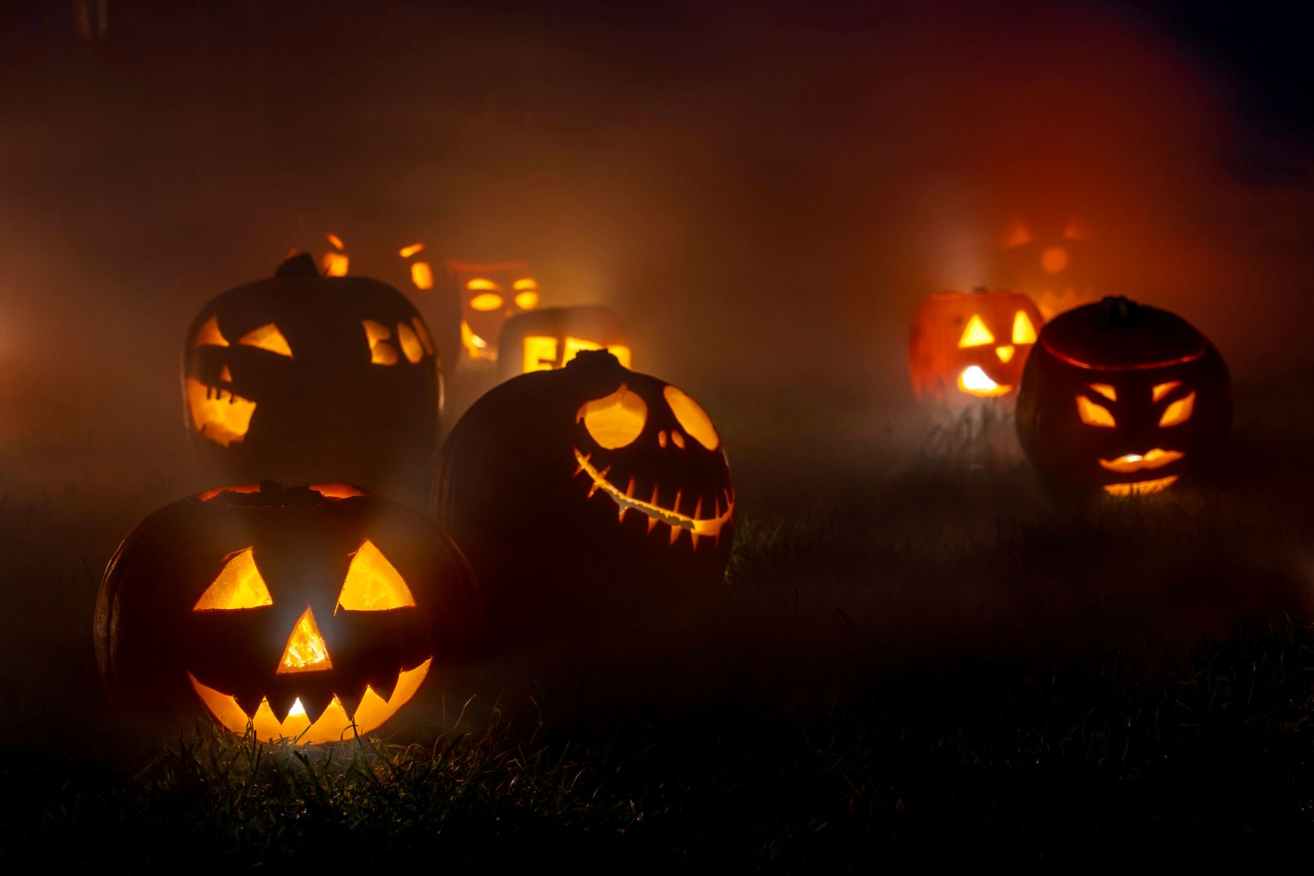 Dovleci sculptați și aprinși la geam de Halloween pe o stradă britanică întunecată