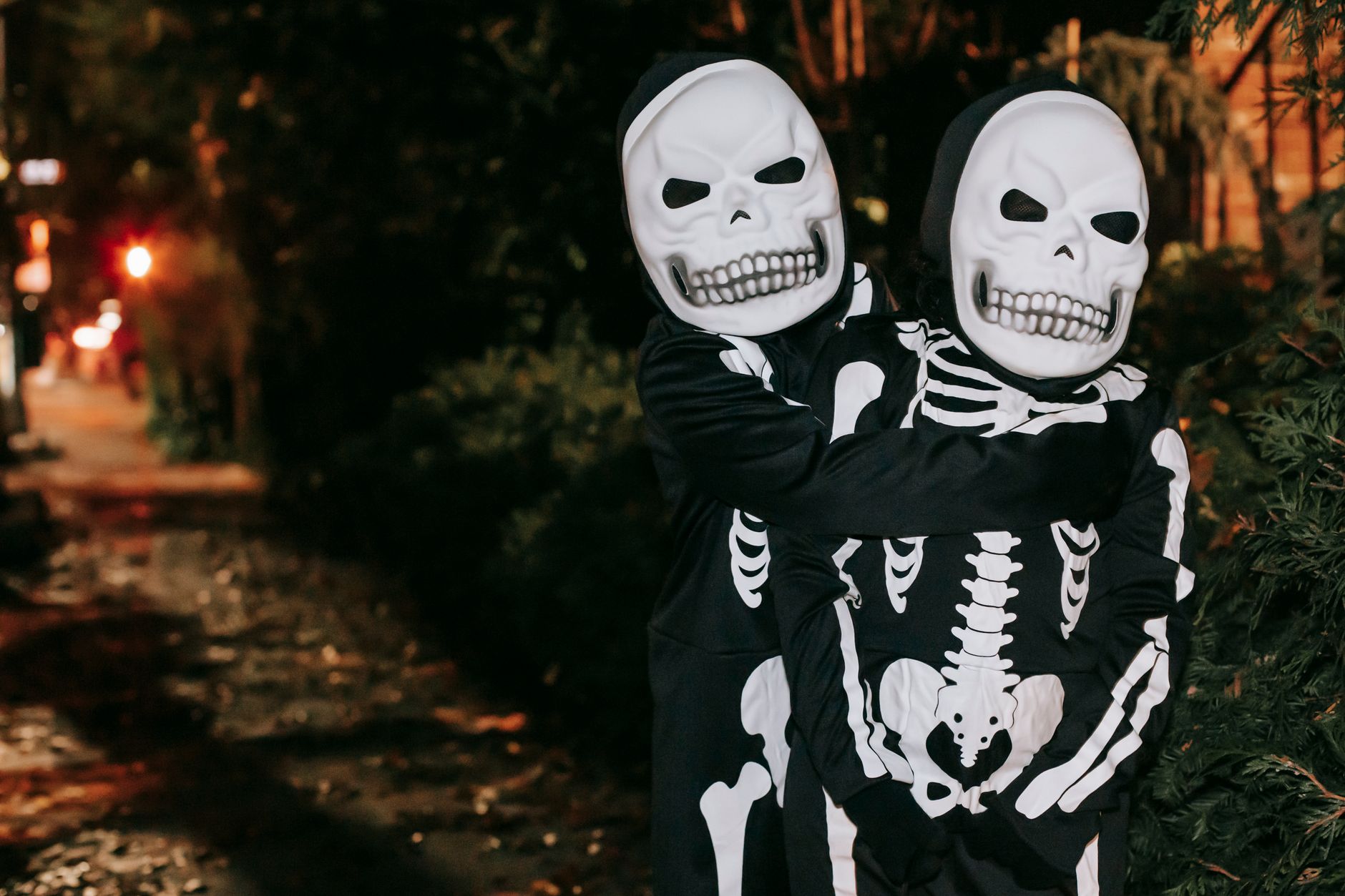 Copii în costume de Halloween care merg la trick-or-treat prin cartier seara